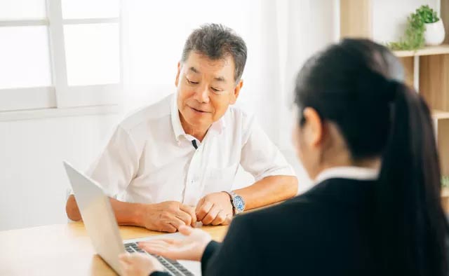 担当プランナーと喪主が葬儀の日程や斎場、予算を決めるための打ち合わせをしている様子。